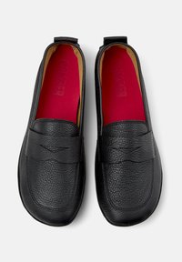 Mustad nahast loafers, millel on tekstuuriga pind, esiosas ristõmblustega disain ja erksad punased sisetallad.