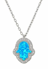 Collar de cadena de plata con un colgante de Hamsa que presenta un centro de ópalo azul brillante y un borde de diamantes brillantes sobre un fondo blanco.