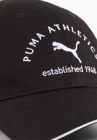 Fekete sapka fehér hímzett "PUMA ATHLETICS" logóval és alapítási dátummal. Jellemzője ívelt karima és strukturált dizájn.