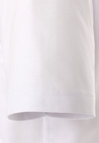 Witte katoenen t-shirtstof met een iets gestructureerd oppervlak. De korte mouw heeft een gerolde zoom en fijne stikseldetails.