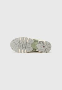 Talpa de sneaker în nuanțe de gri și verde, prezentând un model de profil pentru aderență, cu un accent logo proeminent în centru și un design masiv.