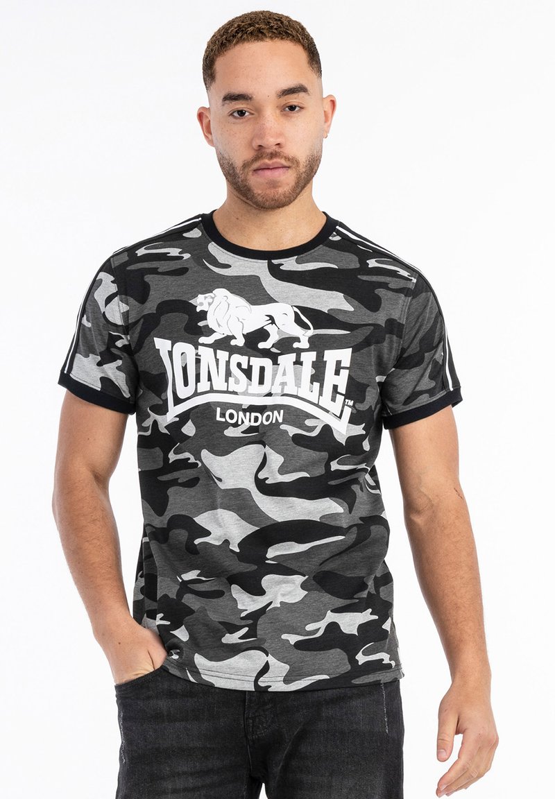 Szürke kamuflázs pamut póló, fehér "Lonsdale London" logóval és oroszlán grafikával, fekete kerek nyakkal és ujjakkal.