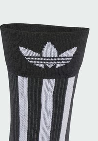 Black athletic sock featuring a white three-stripe design and a white logo at the top. Made of ribbed, stretchy material for comfort.
