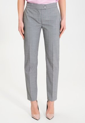 Pantaloni grigi a righe con una vestibilità su misura, chiusura a bottone in vita e tasche, abbinati a una camicetta rosa chiaro e tacchi nudi.