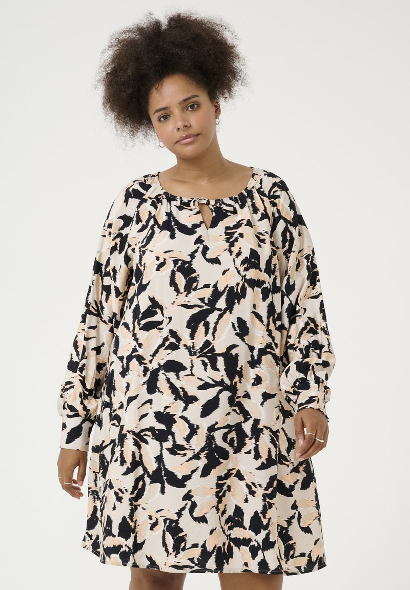 Blumiges Kleid in hellem Creme mit schwarzen und pfirsichfarbigen Tönen. Schlüssel-Ausschnitt, lange Ärmel und lässige Silhouette. Weicher Stoff.