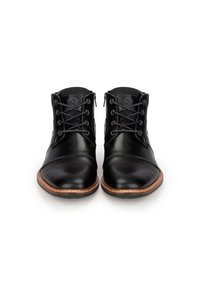 Botas de tobillo de cuero negro con un acabado suave, punta redonda, cordones en la parte delantera y suela marrón contrastante con detalles texturizados.