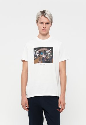 White cotton t-shirt featuring a colorful graphic print of people in a bar scene, with a round neckline and short sleeves.