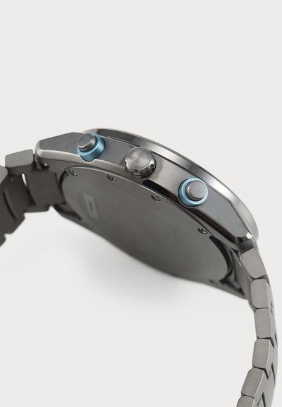 Sort metallur ur med et elegant rundt kabinet, to blå accentknapper og et tekstureret ledarmbånd. Bagsiden er enkel og glat.