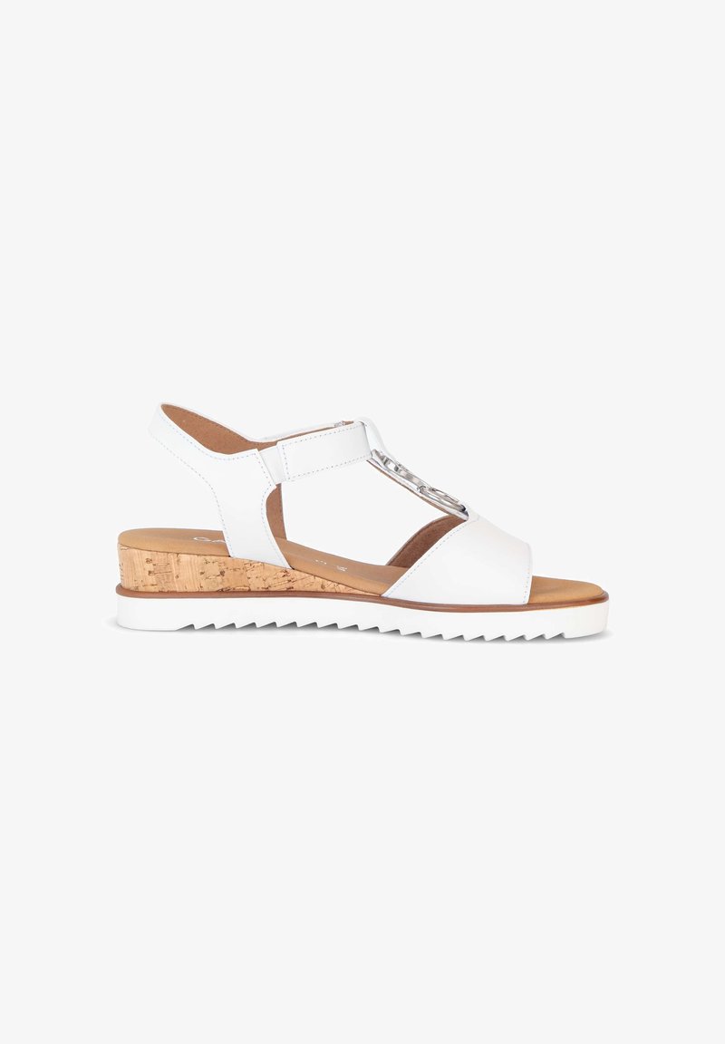 Sandale compensée ouverte en cuir blanc avec talon en liège, bride de cheville ajustable et détail de chaîne argentée sur la bride avant.