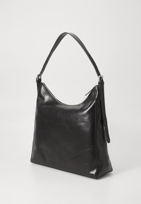 Sac à main en cuir noir avec une finition lisse, une forme semi-structurée, une bandoulière réglable et une ouverture zippée sur le dessus.