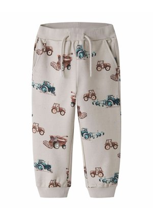 Beige joggers til småbørn med elastisk talje og manchetter, med print af blå og brune traktorer og landbrugsmaskiner.