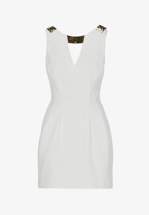 Robe blanche sans manches avec décolleté en V et ornements en sequins noirs et dorés sur les bretelles et le col arrière.