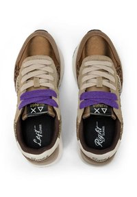 Un paio di sneackers marroni con dettagli beige e stampa leopardata, lacci viola e solette etichettate "Sinistro" e "Destro" su uno sfondo bianco.