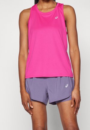 Personne portant un haut de sport sans manches rose vif et un short de sport perforé violet clair avec des logos blancs de la marque sur les deux.