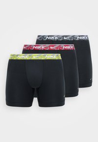 Tri páry čiernych boxeriek s elastickými pásmi, ktoré majú farebné maskáčové vzory v šedej, červenej a žltej farbe, pričom každé obsahuje logo Nike.