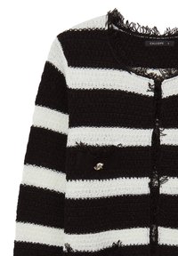 Giacca di tweed a strisce bianche e nere con bordi sfrangiati, scollatura rotonda e un piccolo accento in argento su una tasca frontale.