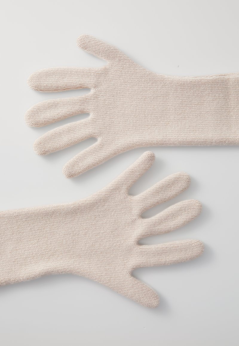 Knitted gloves in a light beige color feature five finger openings and a smooth texture with a subtle pattern.