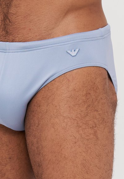 Svetlo modri kopalni hlačniki z gladko teksturo, ki se ponašajo z diskretnim logotipom orla. Elastičen pas udobno prilega.