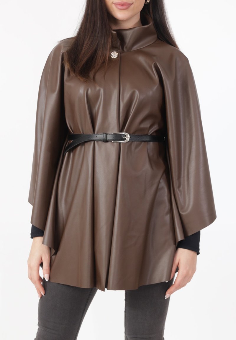 Bruine cape van imitatieleer met een hoge kraag, een getailleerde taille met een zwarte riem, voorzien van een zilveren knoopdetail en een gladde textuur.