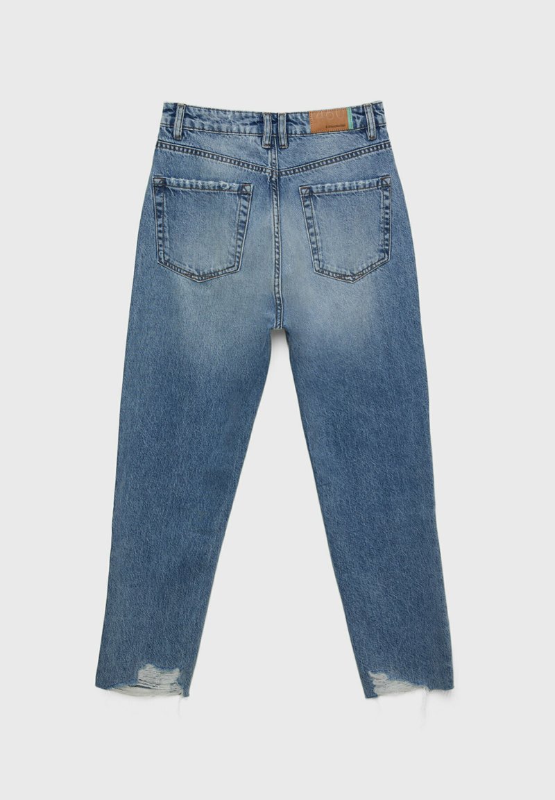 Jean en denim bleu avec une finition légèrement décolorée, design à jambes droites, ourlets effilochés et deux poches arrière. Patch en cuir sur la taille.