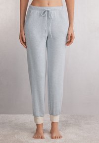Lichtblauwe joggerbroek van zacht materiaal, voorzien van een trekkoord in de taille en witte geribde boorden. Soepele textuur met een relaxte pasvorm.