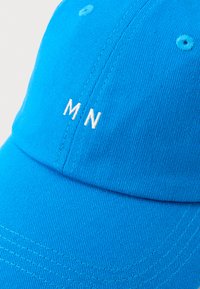 Blå baseballcaps laget av teksturert stoff med hvit brodert "MN"-logo foran. Har sydd detaljer og ventilasjonshull.