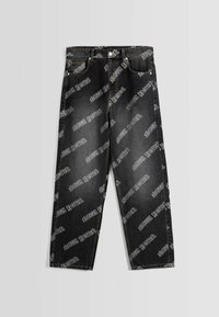 Svarta denimjeans med lös passform, med djärva vita textmönster över hela. Inkluderar framfickor och klassisk knappstängning.