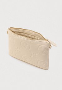 Bolsita de cuero beige para muñeca con patrones de "V" en relieve, cremallera dorada parcialmente abierta y forro interior de tela suave.