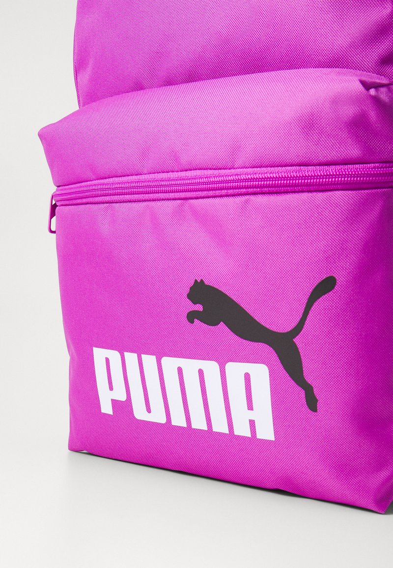 Sac à dos synthétique rose vif avec une finition texturée, arborant un logo Puma noir et un nom de marque blanc sur la poche avant.