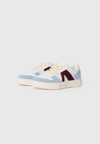 Sneakers with a light blue suede front, white leather sides, and dark red suede accents. Cream laces and a textured beige rubber sole.
