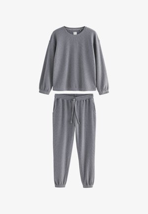 Sivý rebrovaný svetrový sveter s dlhým rukávom a zodpovedajúce jogger nohavice so šnúrkou a elastickými manžetami v neformálnom súprave na voľný čas.
