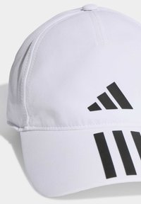 Cappellino da baseball bianco con tessuto testurizzato, visiera curva e tre strisce diagonali nere sulla parte anteriore.