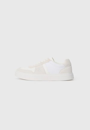 Sneakers with a white and light beige color scheme, featuring a suede and mesh upper, round toe, flat white sole, and subtle logo detailing.