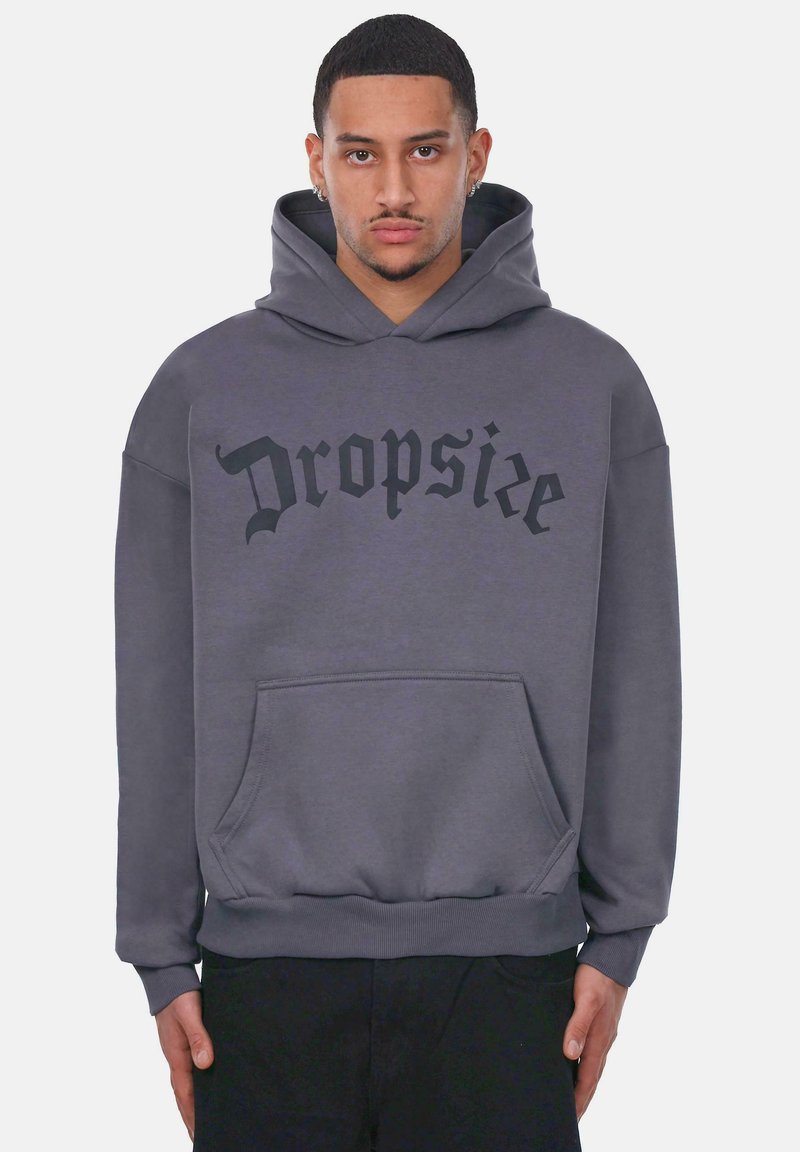 Szary hoodie z przednią kieszenią, na której widnieje napis "Dropsie" w pogrubionej czarnej czcionce. Wykonany z miękkiego materiału, z kapturem na sznurku i ściągaczami na rękawach.