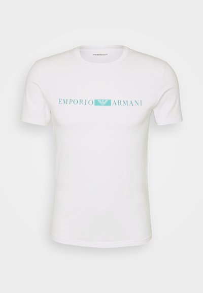 Balta trumpa rankovėmis marškinėliai, pagaminti iš medvilnės, su turkio spalvos "EMPORIO ARMANI" logo krūtinėje. Apvalus kaklas, standartinė forma.