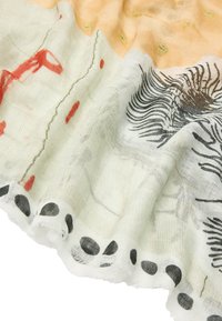 Przezroczysty szalik w jasnym odcieniu kremu, ozdobiony abstrakcyjnymi czarnymi i czerwonymi wzorami, okrągłymi czarnymi akcentami wzdłuż krawędzi oraz miękką, teksturowaną powierzchnią.