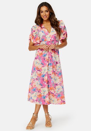 Bloemen midi-jurk in het pink, met pofmouwen en een V-hals. De stof bevat grote bloemen in tinten roze, oranje en blauw.
