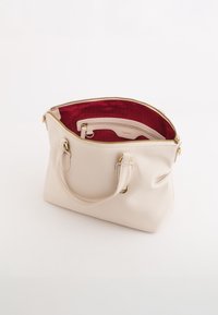 Strukturierte beige Ledertasche mit einer strukturierten Oberfläche, goldfarbener Hardware, Reißverschlüssen und einem rot gefütterten Innenraum mit einer zusätzlichen Tasche.