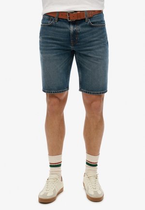 Donkerblauwe denim shorts met een regular fit, voorzien van stikdetails, vijf zakken en een versleten afwerking. Gepaard met lichtgekleurde sneakers.
