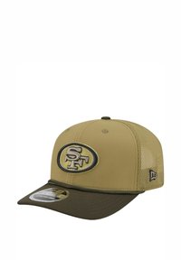 Khakifarbene Baseballkappe mit einem dunkelgrünen Schirm, mit einem gestickten SF-Logo auf einem ovalen Patch. Hergestellt aus Stoff- und Mesh-Materialien.