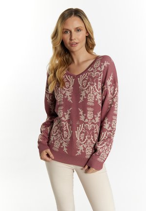 Pulover cu decolteu în formă de V, de culoare mauve, cu modele florale complexe într-o nuanță de crem. Mansete și tiv mânjite. Purtați peste pantaloni bej deschis. Textură moale.