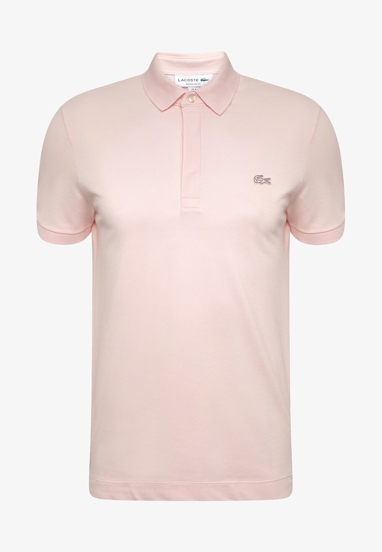 Polo à manches courtes rose clair avec col pointu, patte à deux boutons et petit logo crocodile brodé sur la poitrine gauche.
