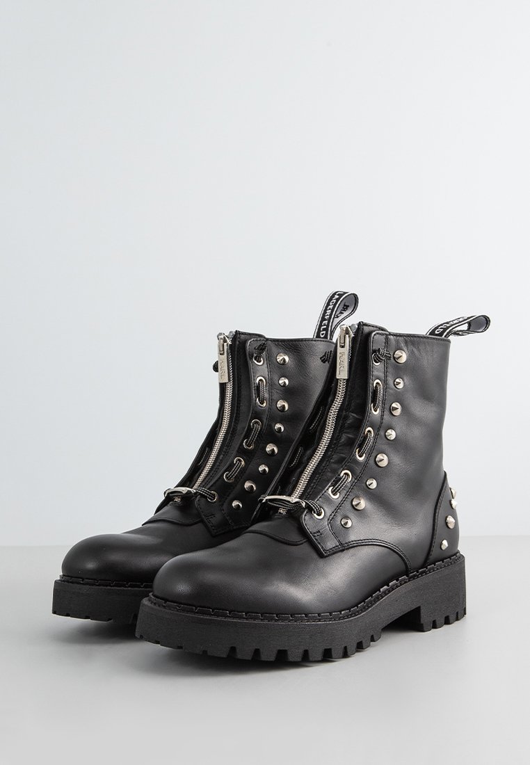 Bottines en cuir noir avec des clous argentés, doubles zips, semelle en caoutchouc robuste et languettes pour un enfilage facile.