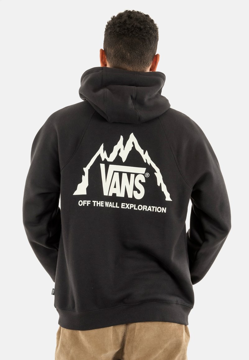 Sudadera negra hecha de tela de mezcla de algodón que presenta un gráfico de montañas blancas y el texto "VANS OFF THE WALL EXPLORATION" en la parte posterior.
