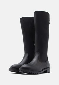 Botas negras hasta la rodilla que combinan cuero liso y gamuza suave, con punta redondeada, suela de goma texturizada y detalle de cremallera lateral.