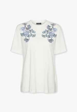 Camiseta blanca de manga corta con patrones de hojas bordadas en azul y púrpura en ambos hombros y cuello redondo.