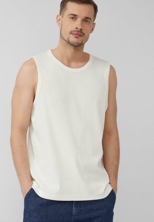 White sleeveless tank top made of ribbed fabric, featuring a round neckline and a relaxed fit, paired with dark denim shorts.
