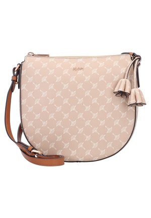 Beżowa torebka na ramię w kształcie półksiężyca z białym kwiatowym wzorem, brązowym regulowanym paskiem, złotym zamkiem błyskawicznym i ozdobnymi skórzanymi frędzlami na białym tle.