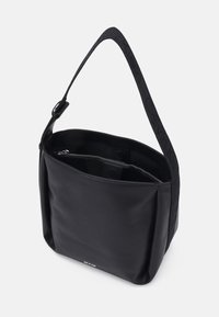 Sac à épaule noir avec une large sangle ajustable, ouverture supérieure dévoilant une poche intérieure zippée et des fermetures magnétiques à l'intérieur.
