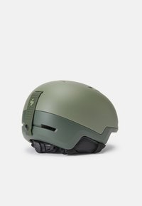 Casco da sci verde opaco con cinturino regolabile, slot di ventilazione e design a profilo basso. Presenta una imbottitura testurizzata per il comfort.